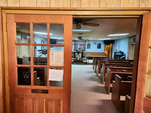 a view of living room with stainless steel appliances kitchen island granite countertop a refrigerator and a stove top oven