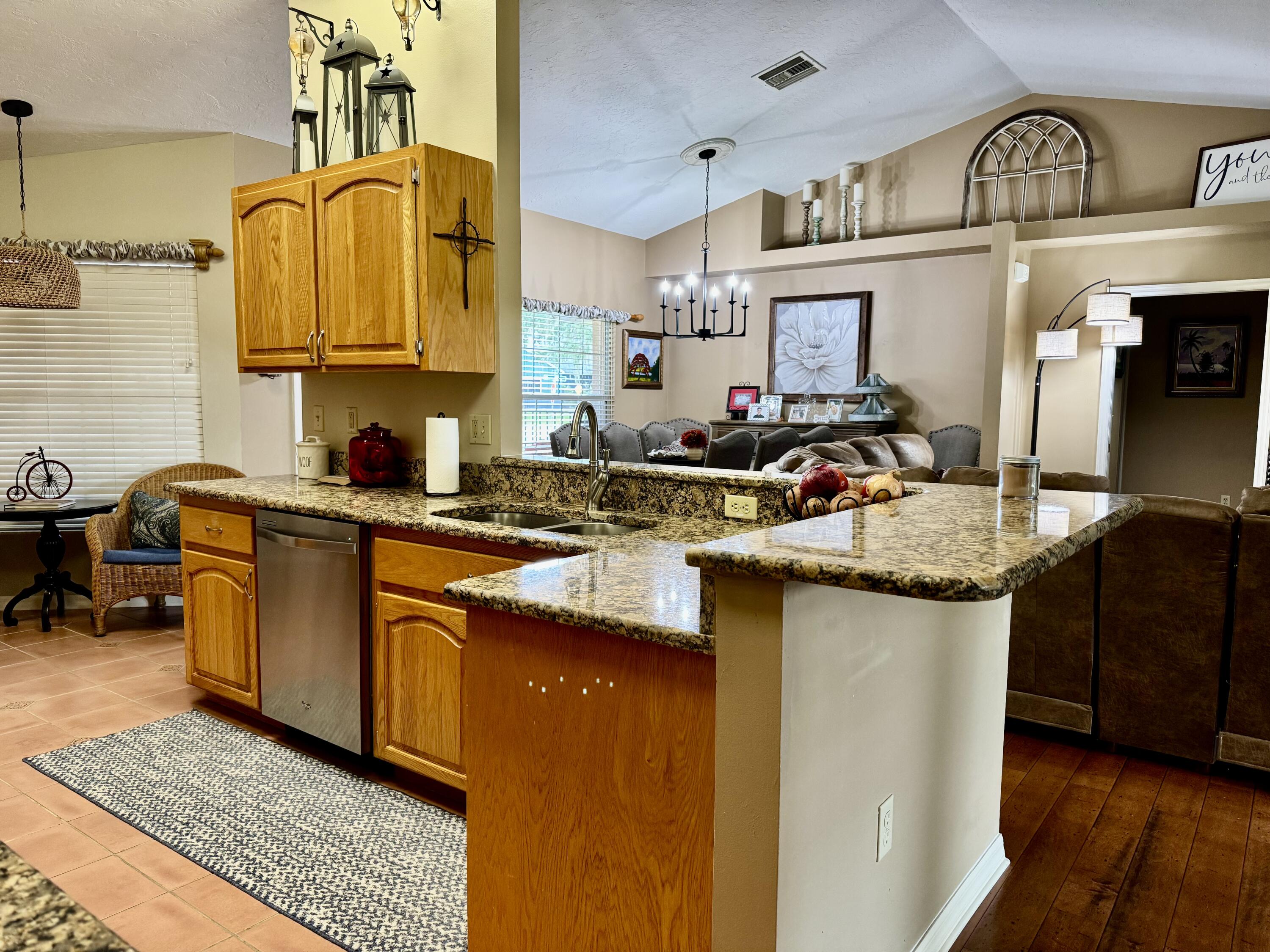603 Southwest 15th Street Okeechobee, FL 34974 - Photo 9 of 40 a kitchen with stainless steel appliances granite countertop a sink stove and cabinets