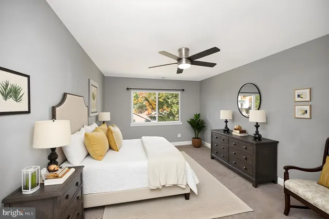 a bedroom with a bed window table and chair