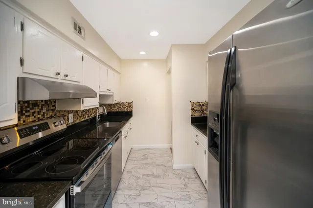 a kitchen with stainless steel appliances a refrigerator and a stove
