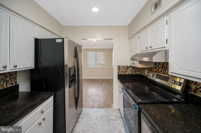 a kitchen with a refrigerator stove and cabinets