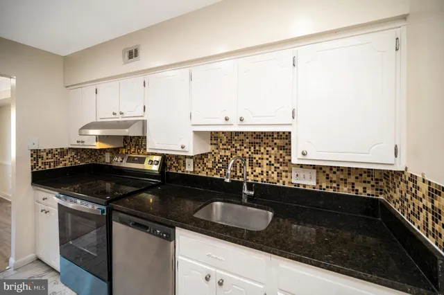 a kitchen with granite countertop a sink and a stove