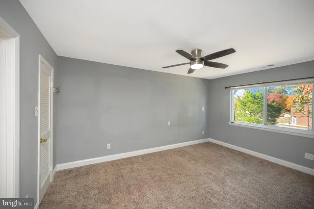 a view of a livingroom with a ceiling fan and window
