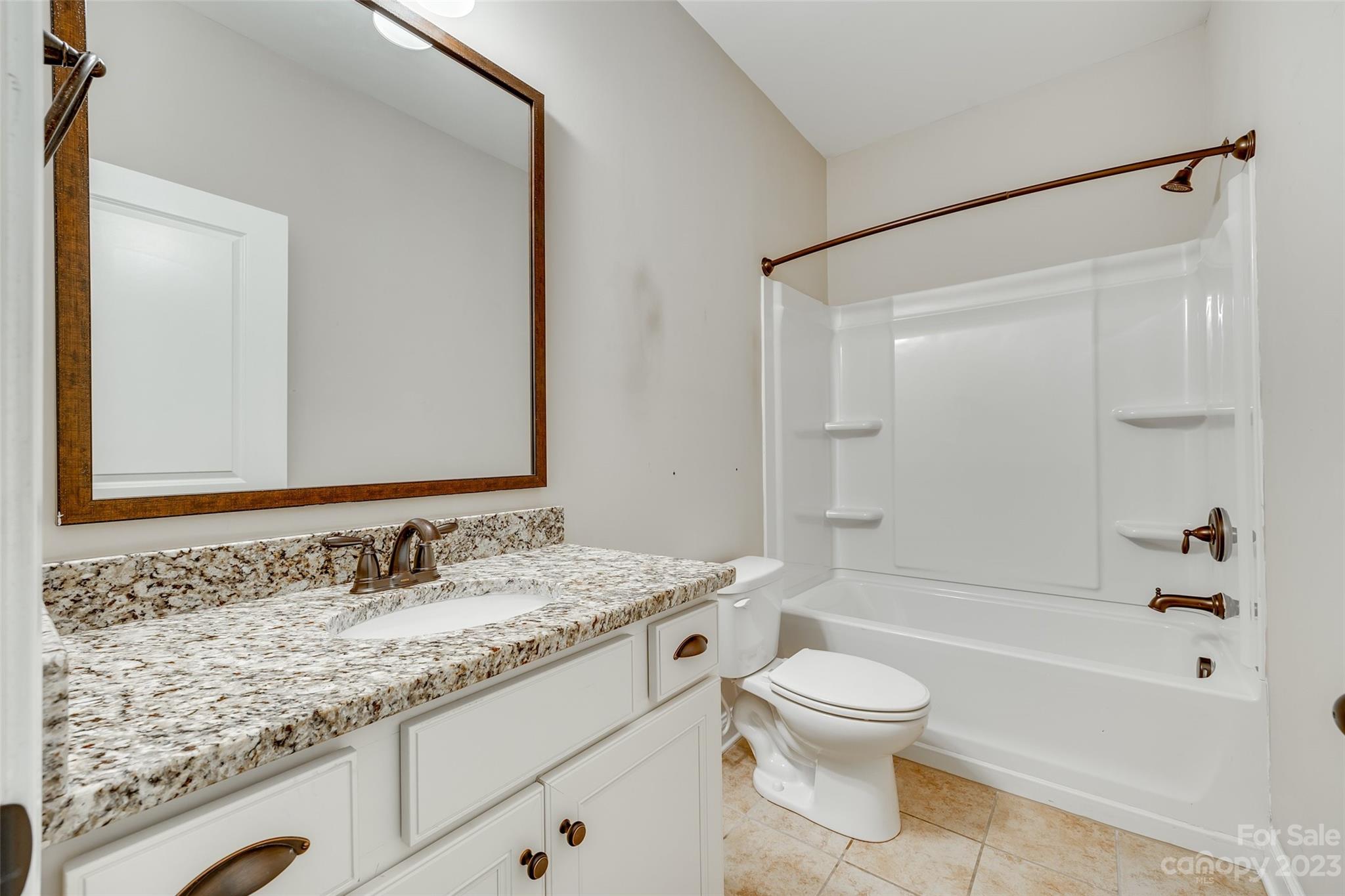 868 Coralbell Way Tega Cay, SC 29708 - Photo 20 of 45 a bathroom with a granite countertop sink toilet a shower and a mirror
