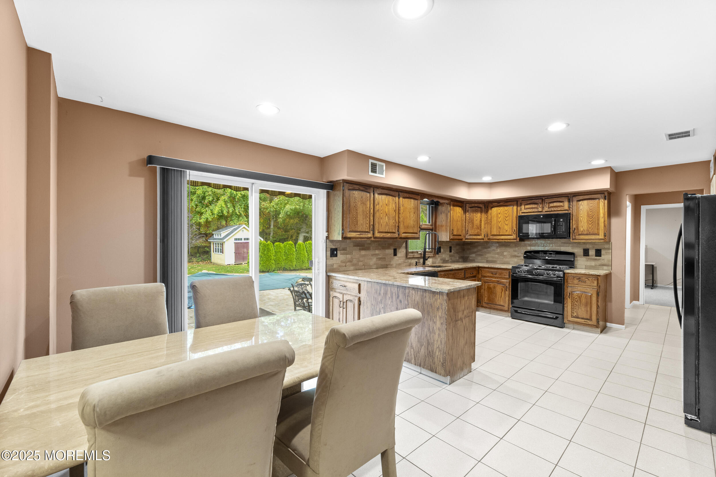 16 Timber Lane Manalapan, NJ 07726 - Photo 11 of 54 a living room with stainless steel appliances kitchen island granite countertop a refrigerator a sink dishwasher a dining table and chairs with wooden floor