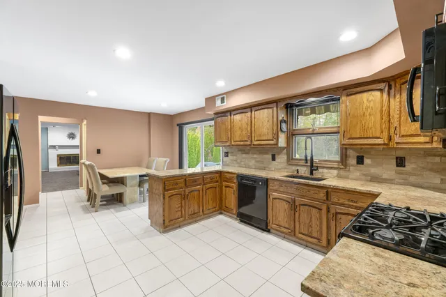a kitchen with granite countertop a refrigerator and a stove top oven