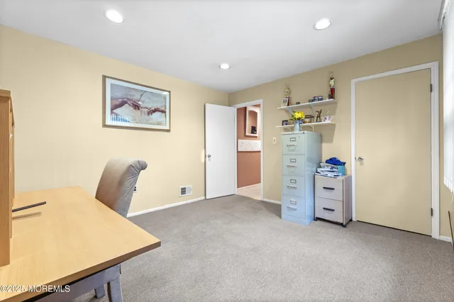 a spacious bedroom with a bed a dresser and large window