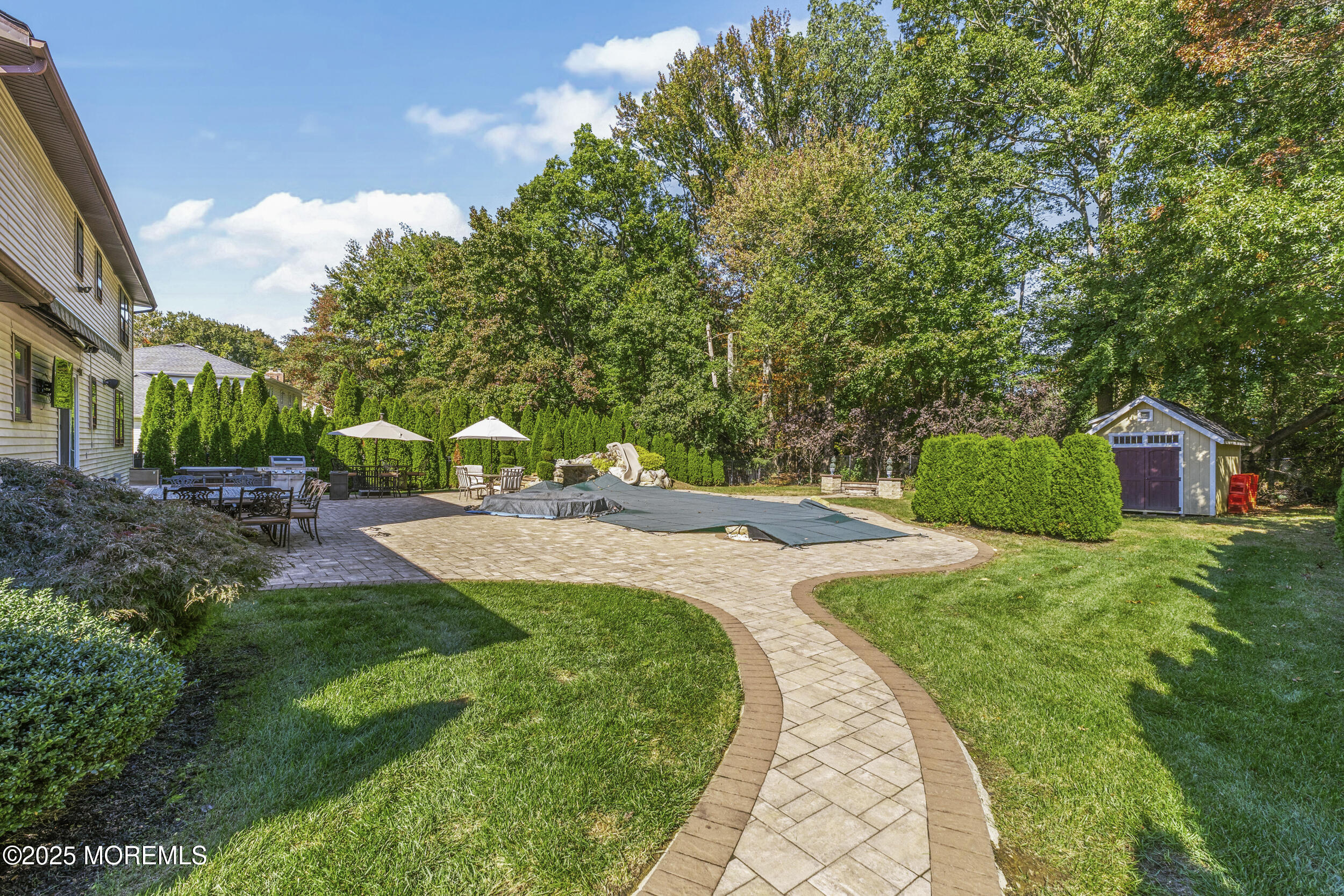 16 Timber Lane Manalapan, NJ 07726 - Photo 42 of 54 a view of a backyard with potted plants and large trees