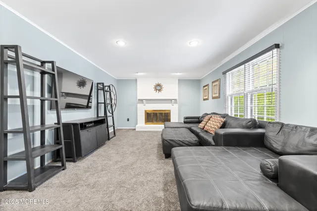 a living room with stainless steel appliances kitchen island granite countertop a refrigerator a sink dishwasher a dining table and chairs with wooden floor