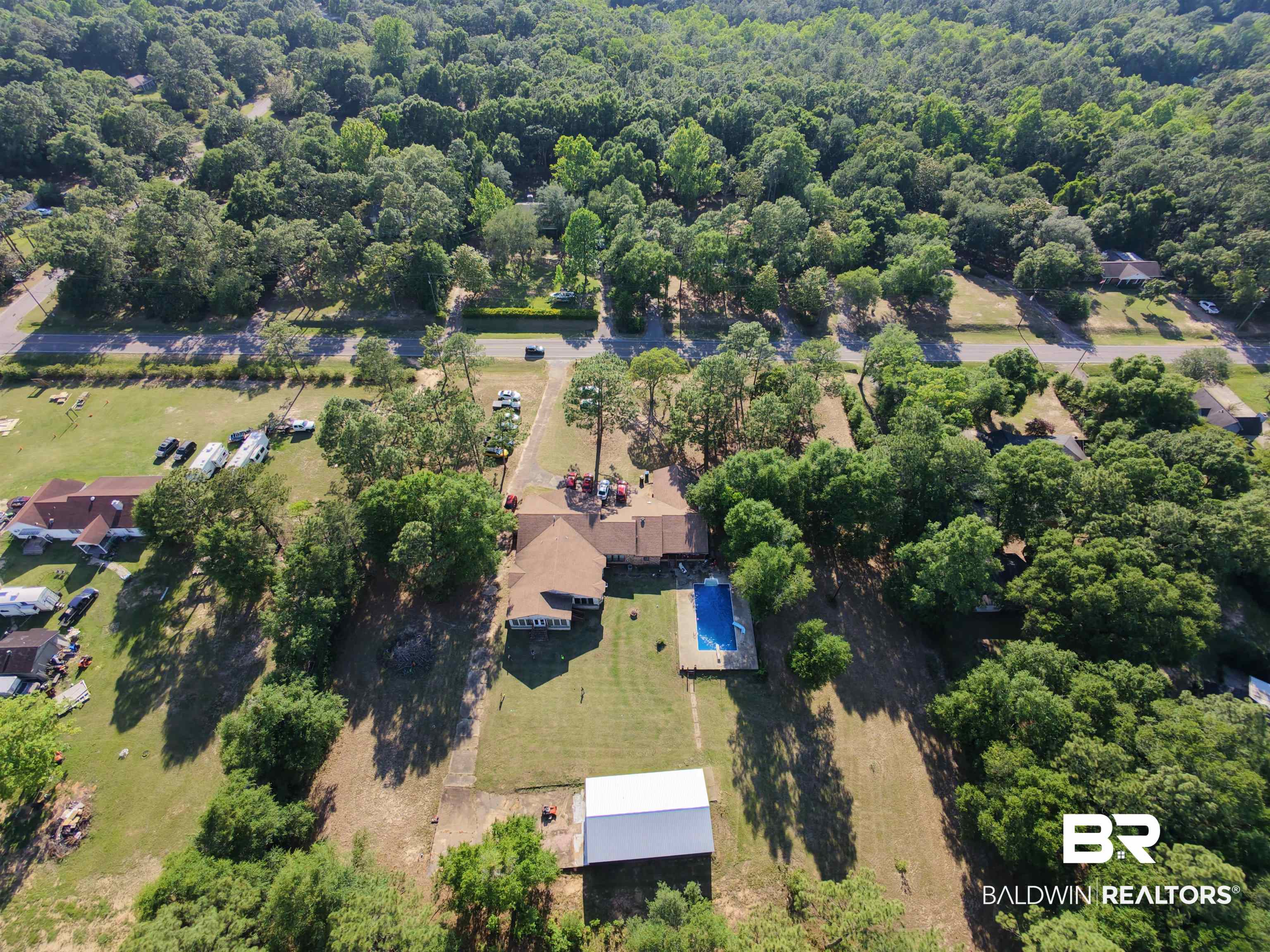 3711 Leroy Stevens Road Mobile, AL 36619 - Photo 1 of 4 Expansive property featuring a single-story residence with a brown shingle roof, surrounded by mature trees