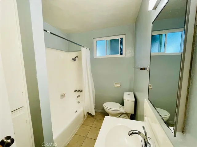 a view of an empty room and chandelier fan