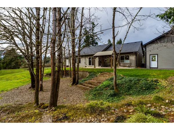 a view of a house with backyard and a tree