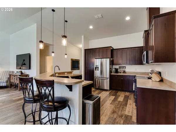 a kitchen with stainless steel appliances kitchen island granite countertop a sink a stove a refrigerator and a refrigerator