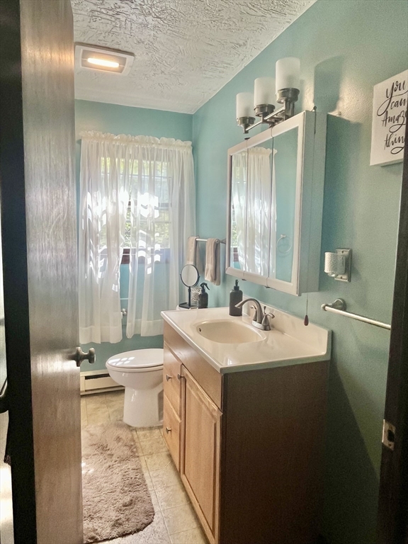 15 Old County Road Holland, MA 01521 - Photo 18 of 22 a bathroom with a sink a toilet a mirror and shower