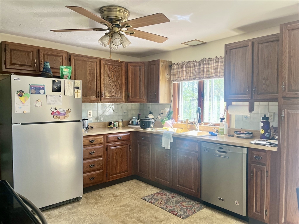 15 Old County Road Holland, MA 01521 - Photo 3 of 22 a kitchen with stainless steel appliances granite countertop a refrigerator a sink dishwasher a stove with wooden cabinets and floor