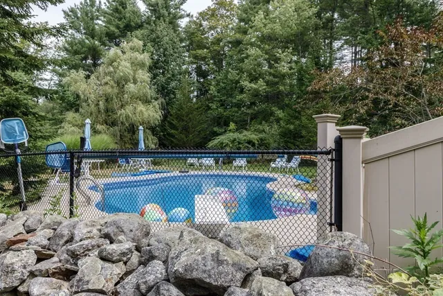 a view of a house with pool and chairs