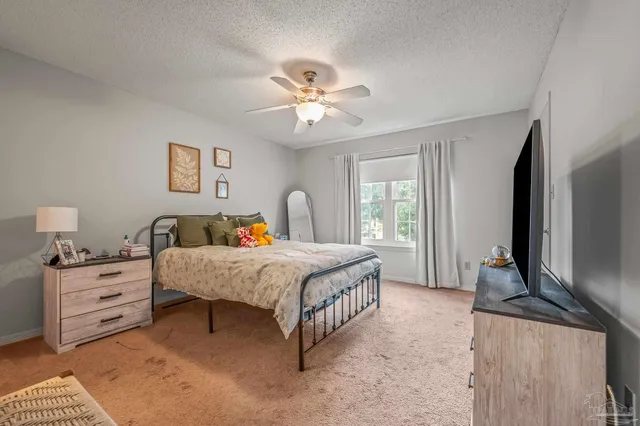 a spacious bedroom with a bed and a flat screen tv