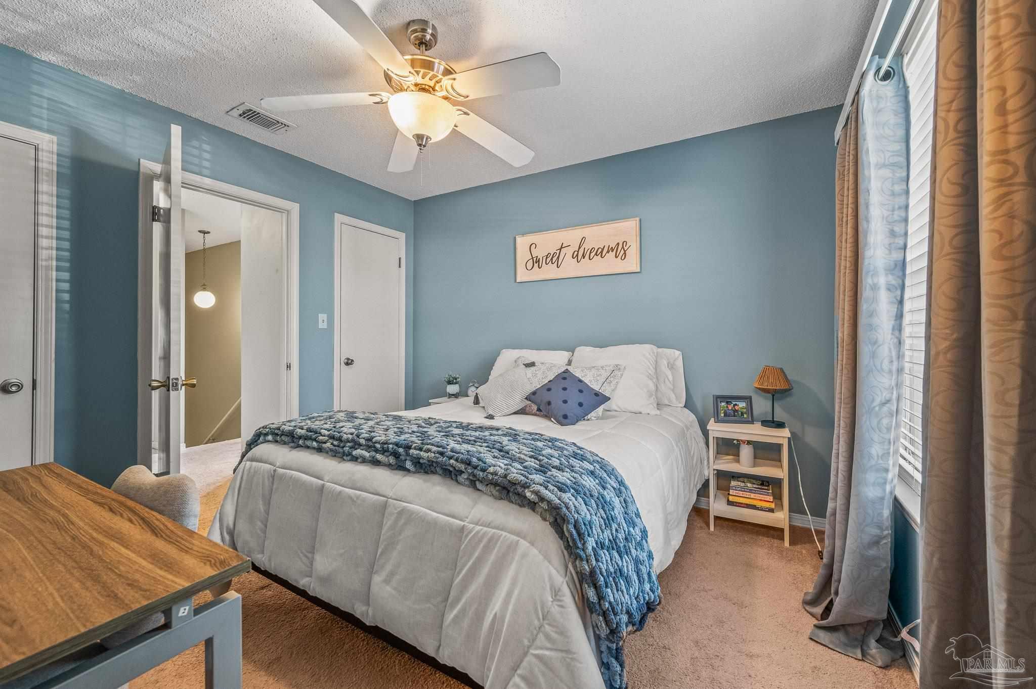 601 East Burgess Road, Unit K1 Pensacola, FL 32504 - Photo 35 of 41 a bedroom with a bed and a chandelier
