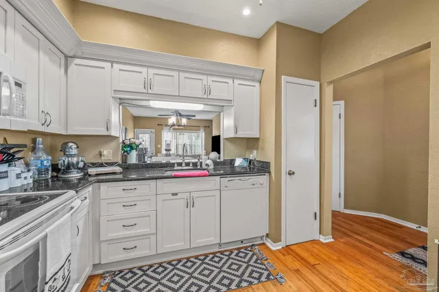 a kitchen with granite countertop a sink and cabinets