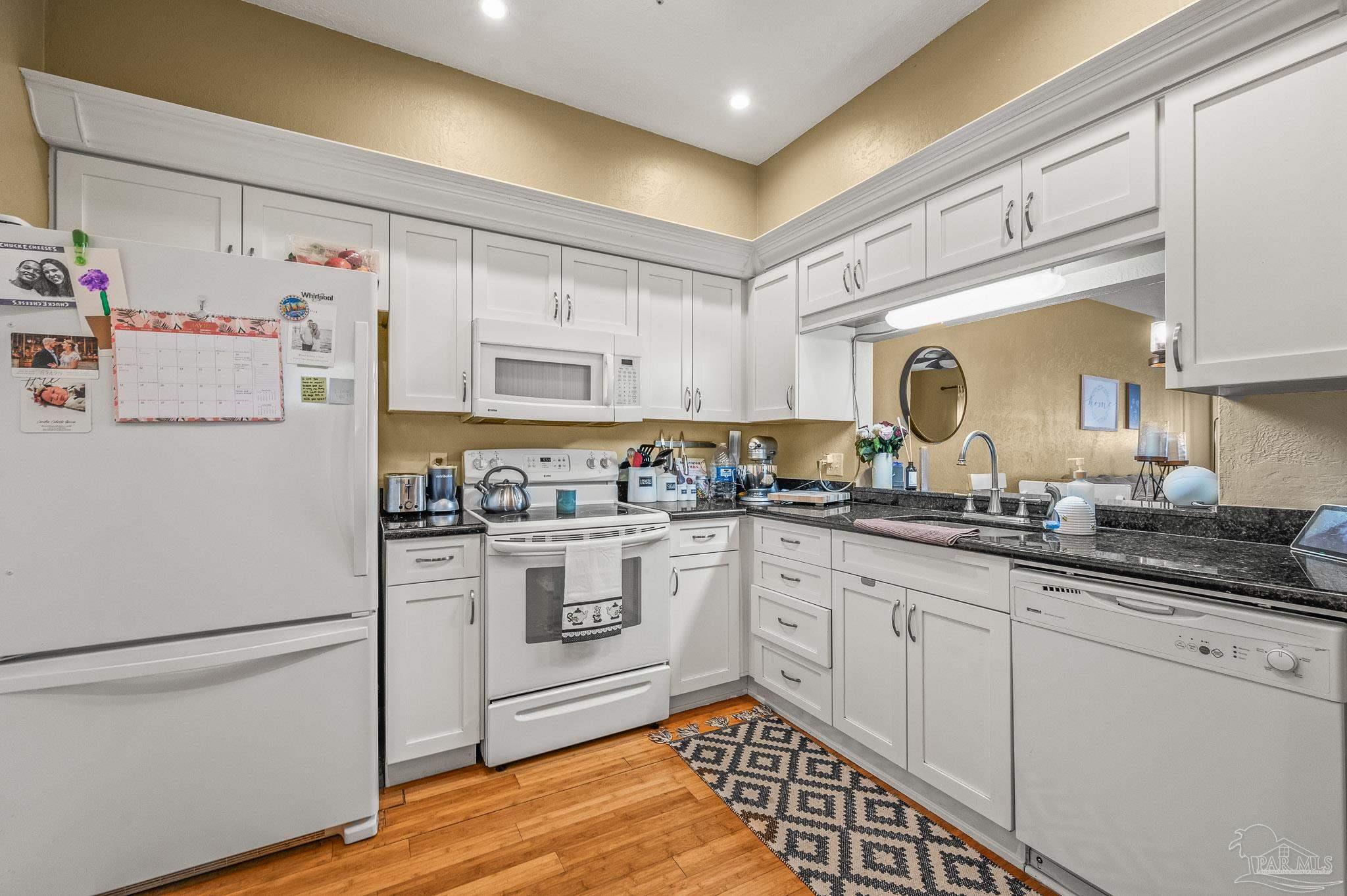 601 East Burgess Road, Unit K1 Pensacola, FL 32504 - Photo 9 of 41 a kitchen with granite countertop white cabinets and white appliances