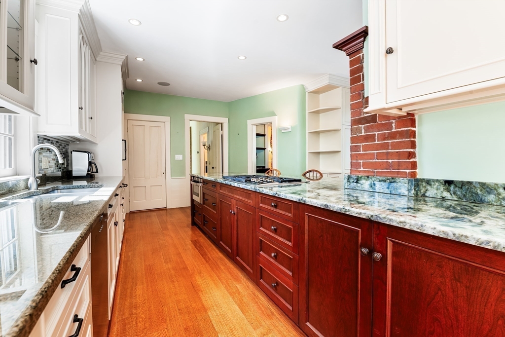 62 Old River Place Dedham, MA 02026 - Photo 11 of 39 a large kitchen with kitchen island granite countertop a sink and wooden cabinets