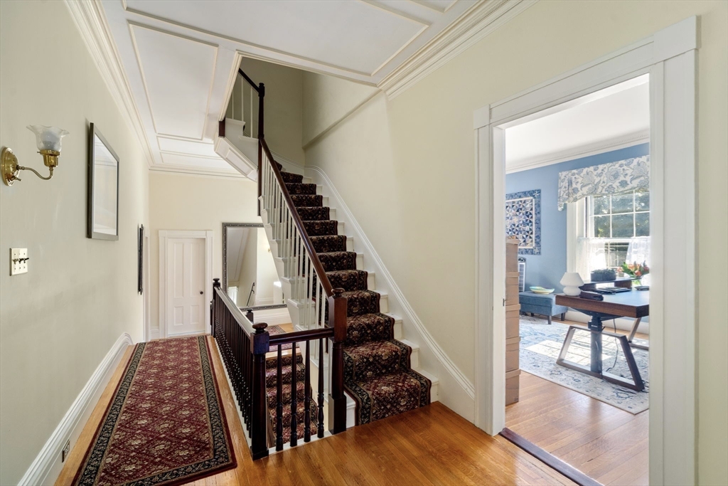 62 Old River Place Dedham, MA 02026 - Photo 21 of 39 a view of a hallway to a livingroom with wooden floor and furniture
