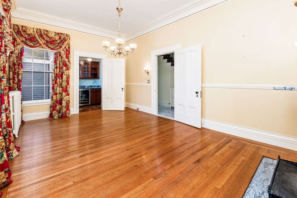 62 Old River Place Dedham, MA 02026 - Photo 9 of 39 a view of an empty room with wooden floor and a window
