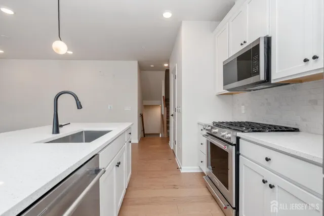 a kitchen with stainless steel appliances granite countertop a sink and a stove top oven