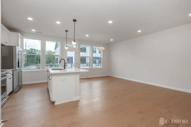 a kitchen with kitchen island a counter top space appliances and a ceiling fan