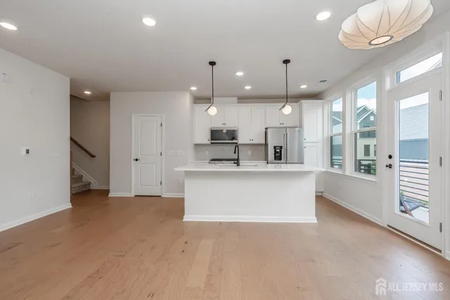a large kitchen with a large window and stainless steel appliances