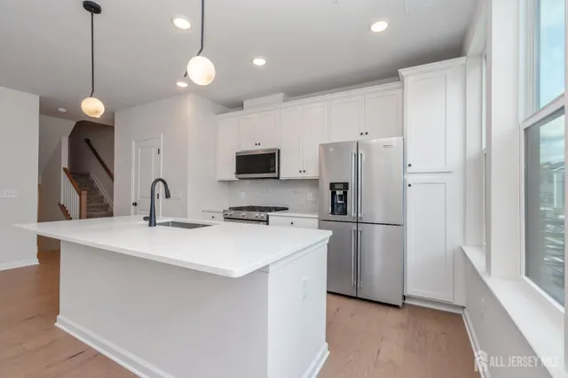 a kitchen that has a refrigerator a sink and a stove top oven