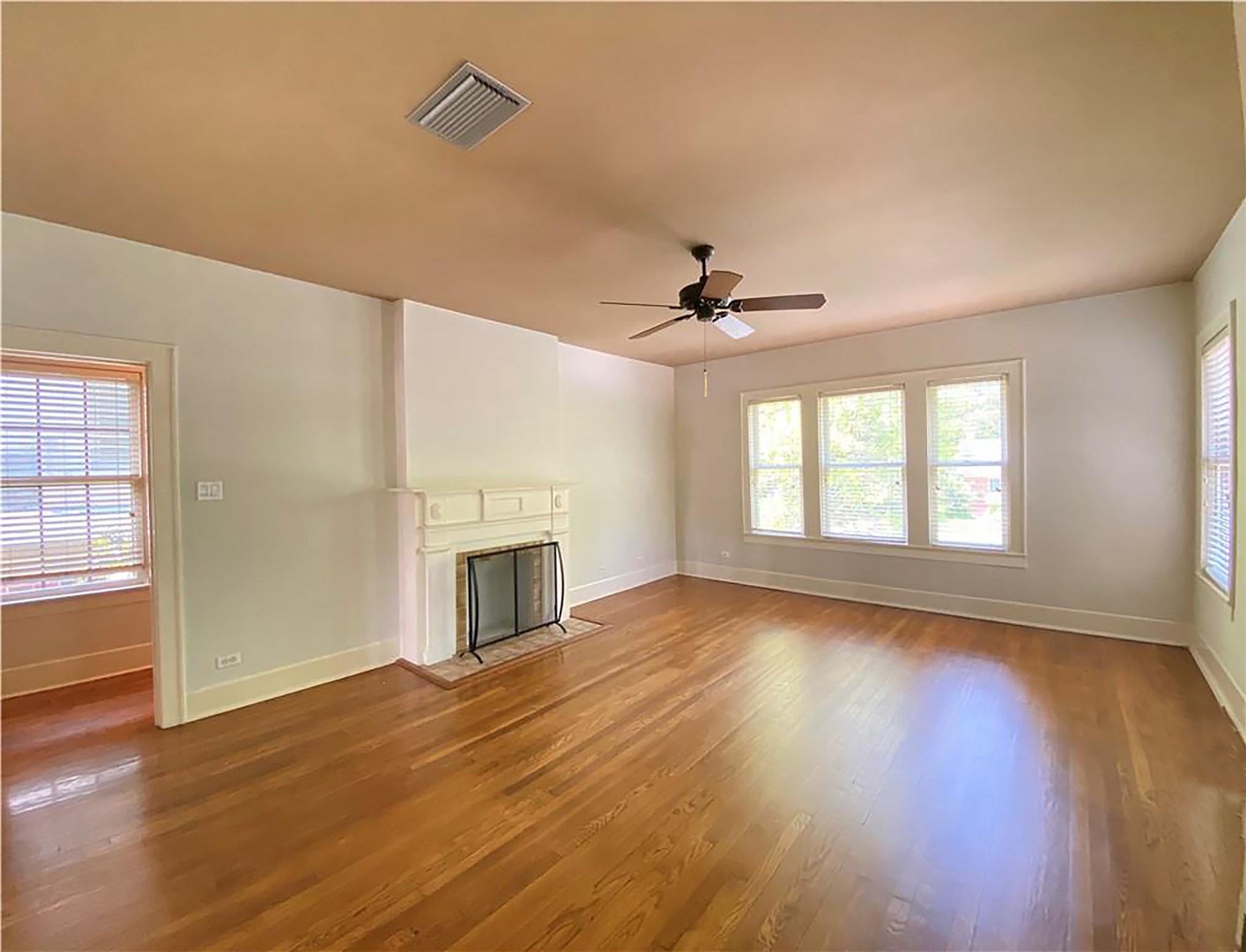609 Texas Austin, TX 78705 - Photo 4 of 18 Unfurnished living room with a fireplace with flush hearth, dark wood-type flooring, and ceiling fan.
