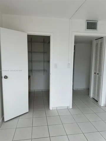 a view of an empty room and closet area