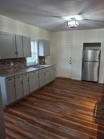 a kitchen with stainless steel appliances granite countertop a sink refrigerator and cabinets