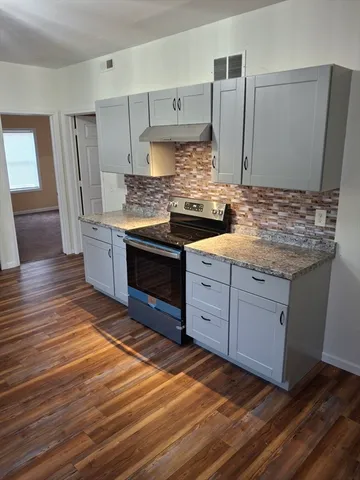 a kitchen with stainless steel appliances granite countertop a sink stove and cabinets