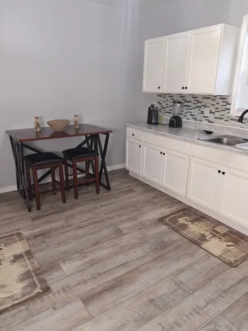 a kitchen with stainless steel appliances a sink a stove a table and chairs