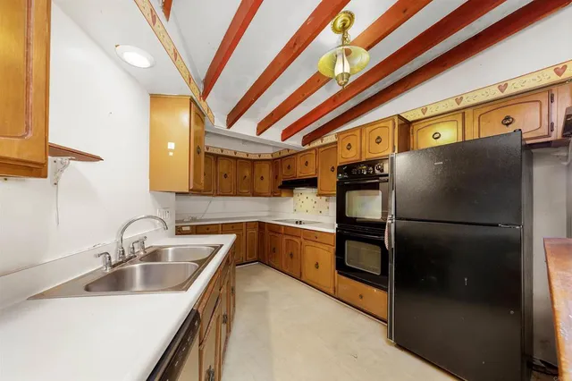 a kitchen with stainless steel appliances a refrigerator a sink a stove and cabinets