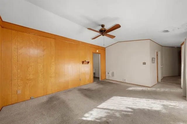 a view of a big room with a ceiling fan and a window