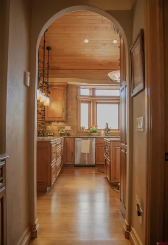 a view of a kitchen with a sink and dishwasher with wooden floor