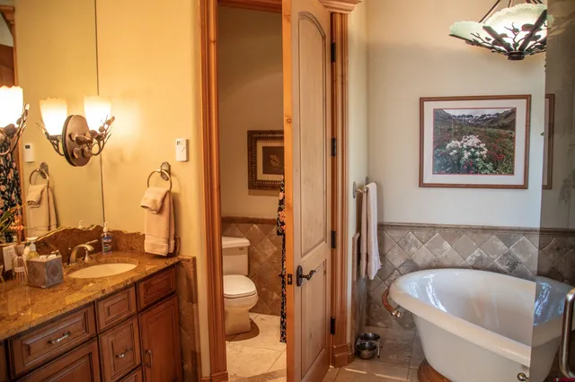 a bathroom with a tub sink and mirror
