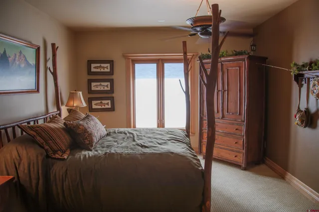 a bedroom with a bed a dresser and a chandelier
