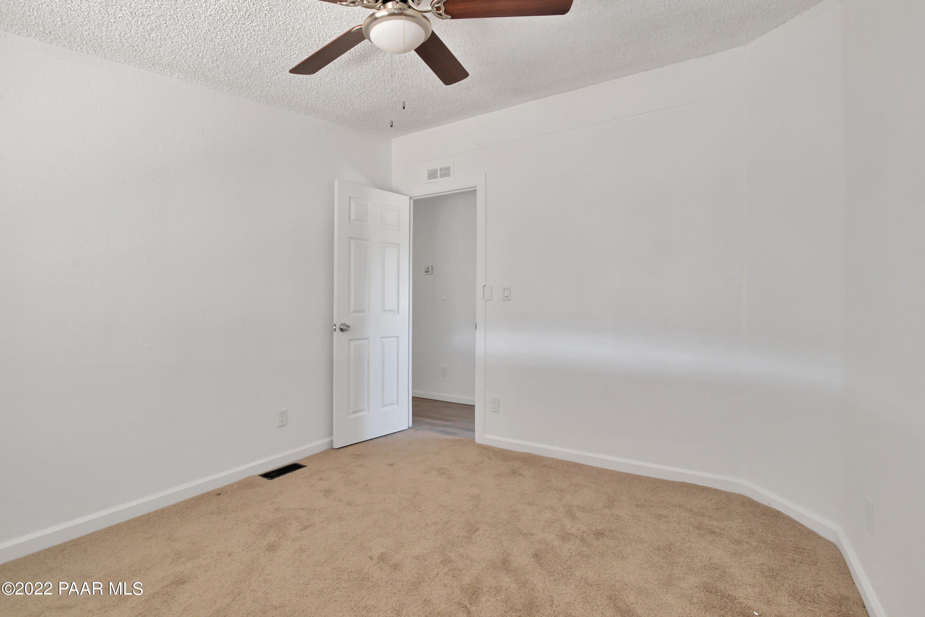 4515 Quail Hollow Road Rimrock, AZ 86335 - Photo 12 of 33 an empty room with a ceiling fan and carpet