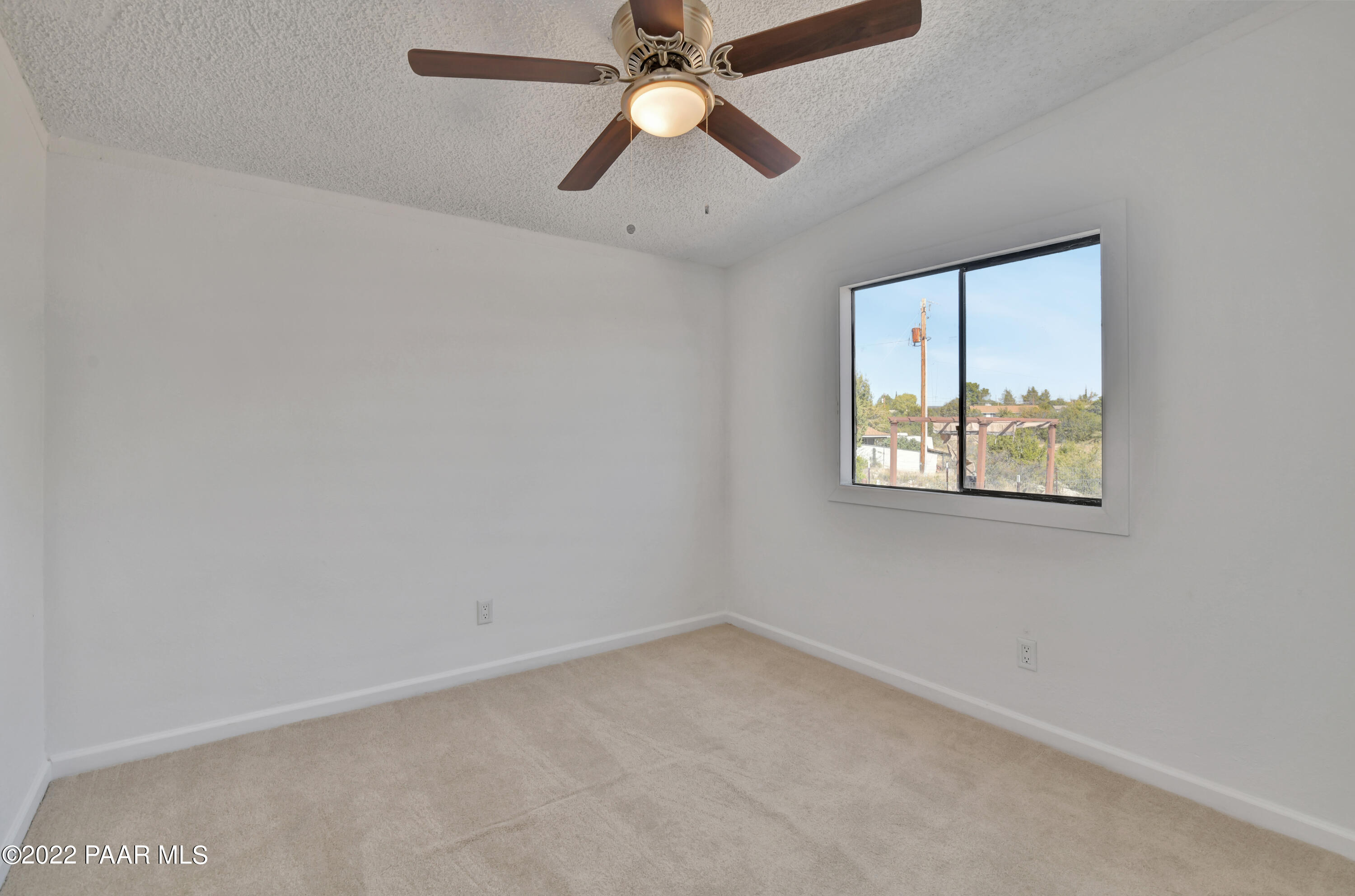 4515 Quail Hollow Road Rimrock, AZ 86335 - Photo 15 of 33 an empty room with chandelier fan and windows
