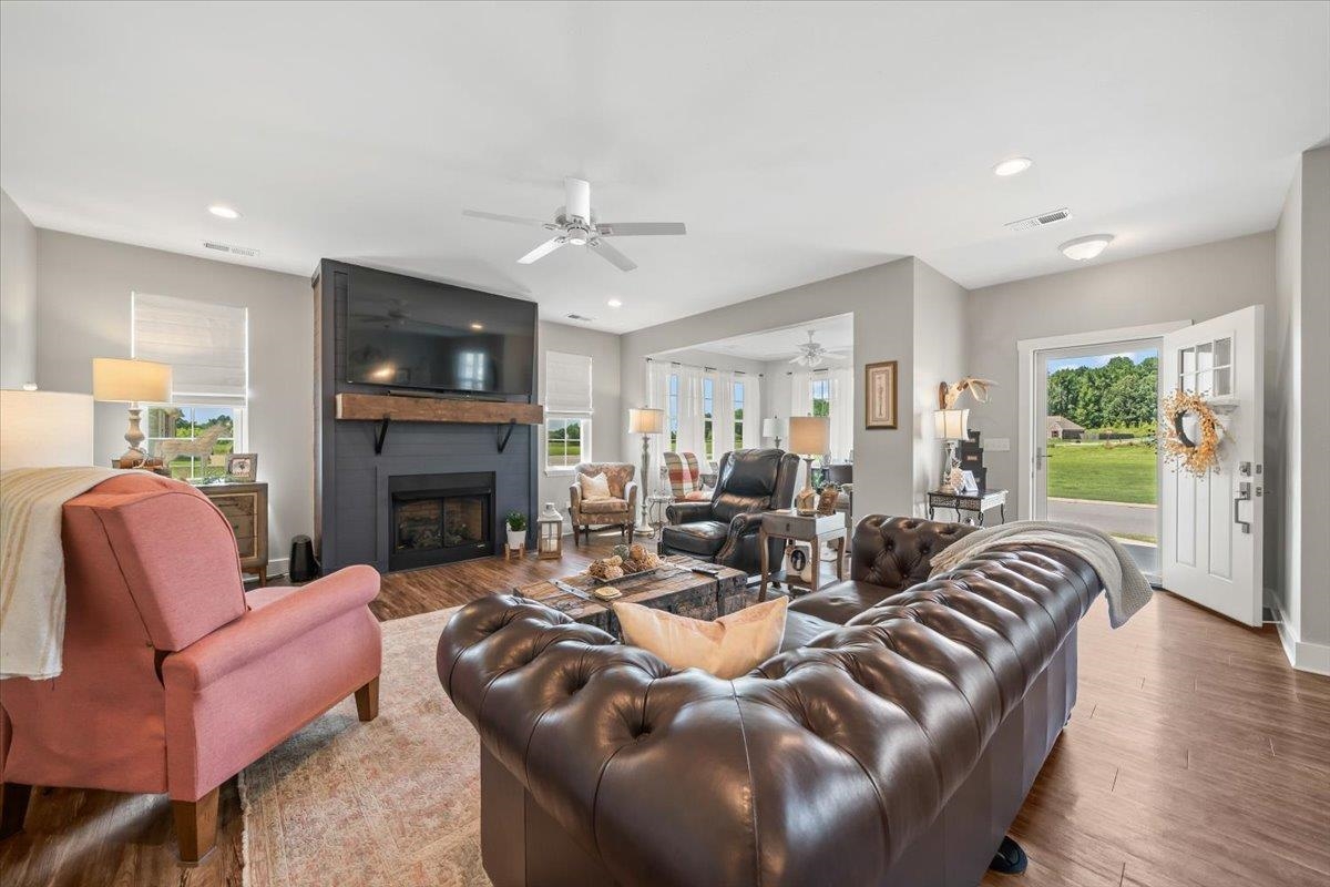 415 Abbey Road, Unit D Munford, TN 38058 - Photo 4 of 35 Spacious living area featuring wood-finish flooring, a contemporary fireplace with a dark surround and wooden mantel, recessed lighting, and a ceiling fan