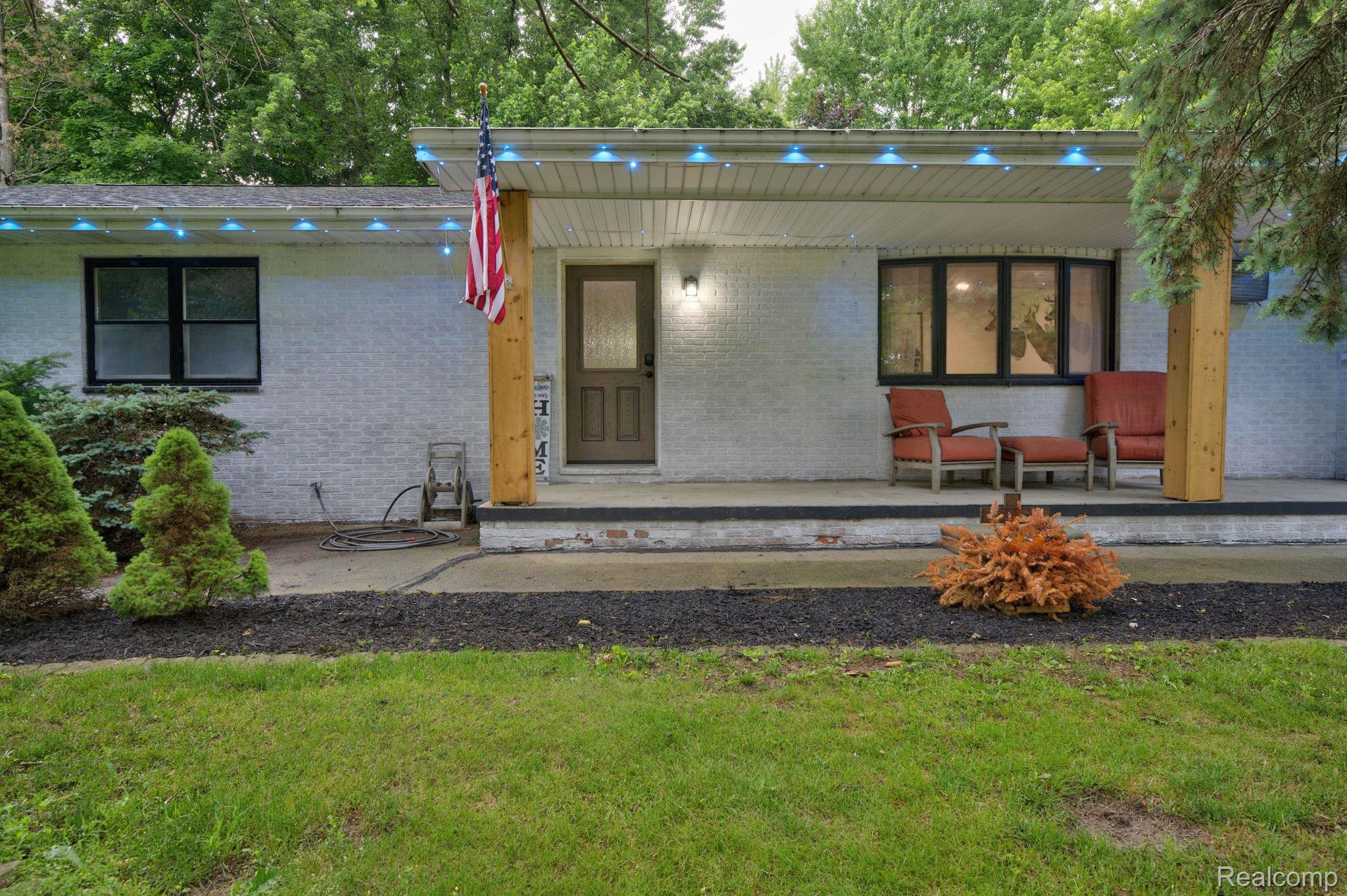 5330 Sheridan Road Saginaw, MI 48601 - Photo 6 of 50 Exterior featuring a white brick facade, covered front porch, and a brown entry door with frosted glass