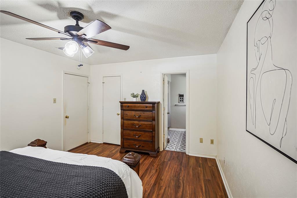 1203 Springbrook Circle DeSoto, TX 75115 - Photo 19 of 27 Bedroom featuring dark wood-style floors, a textured ceiling, a ceiling fan, ensuite bath, and a closet