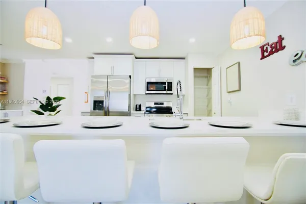 a kitchen with stainless steel appliances kitchen island granite countertop a sink and a refrigerator