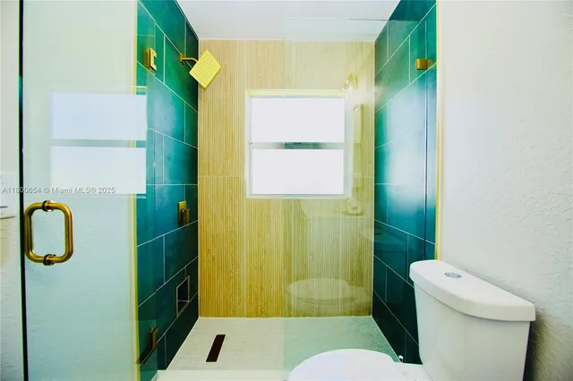 a bathroom with a toilet and a shower