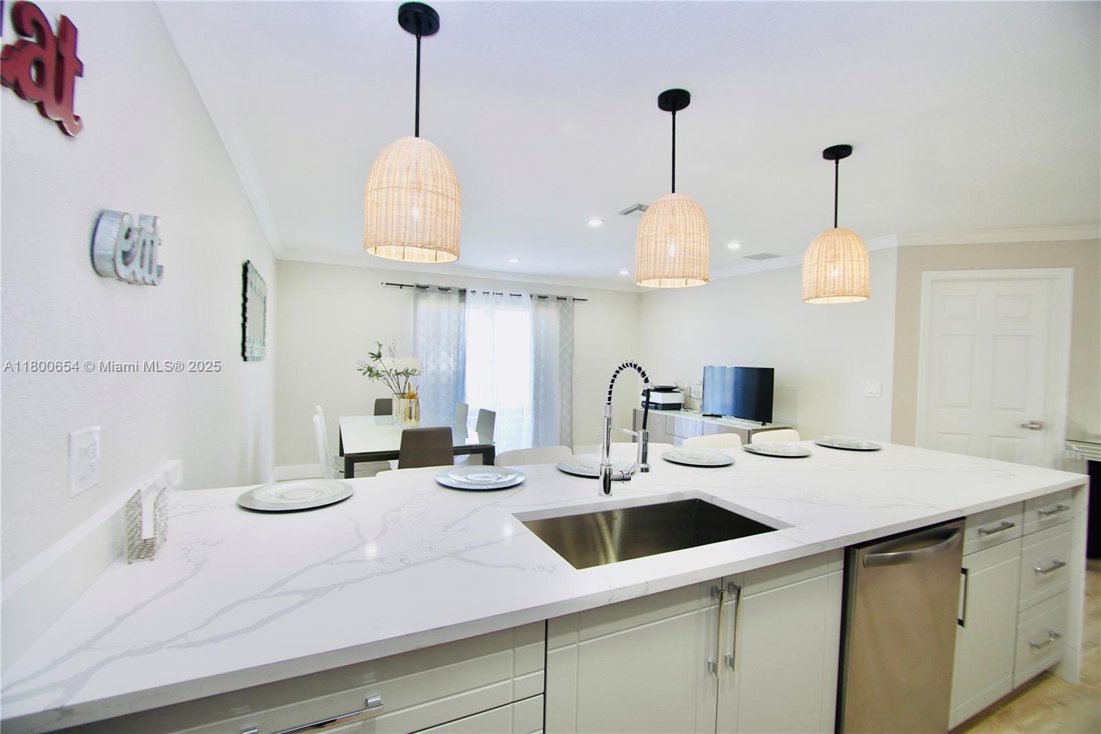 244 Northwest 6th Avenue, Unit 244 Delray Beach, FL 33444 - Photo 2 of 35 a kitchen with a sink and a chandelier