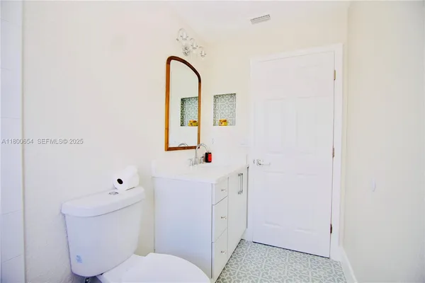 a bathroom with a sink a toilet and a mirror